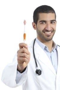Arab doctor man showing a toothbrush